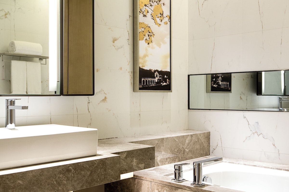 A modern bathroom with a large sink, a separate shower area, and a mirror above the sink.