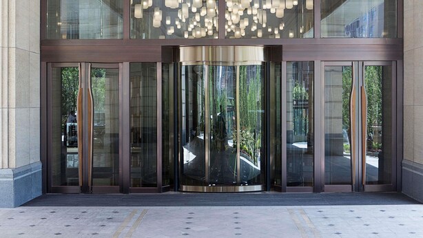 A modern building entrance with large glass doors, a metal frame, and a hanging light fixture. - Pullman Taiyuan (Taiyuan)