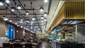 A restaurant with multiple dining tables, overhead lighting, a kitchen area with copper pots, and a marble countertop. - Pullman Taiyuan (Taiyuan)