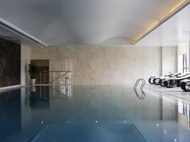 Una piscina techada, sillones reclinables de piscina