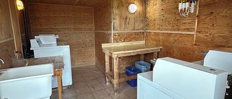 Een kleine keuken met houten wanden, een houten plafond, een spoelbak, een fornuis en een tafeltje.