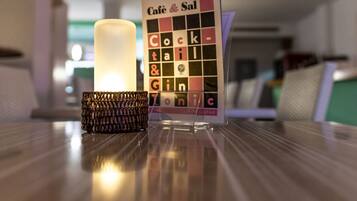 Uma mesa com uma vela e um cardápio intitulado 'Café & Sal'.