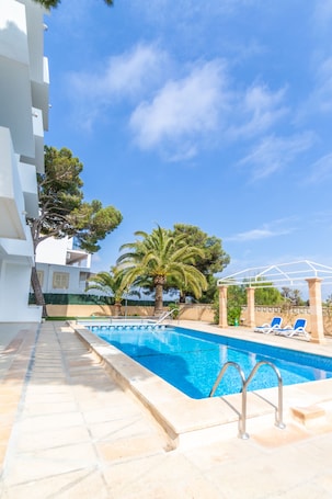 Una piscina al aire libre de temporada, sillones reclinables de piscina