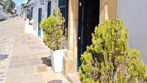 A street with buildings, a sign for a hotel, and potted plants. - Hotel Meson de los Virreyes (Villa de Leyva)