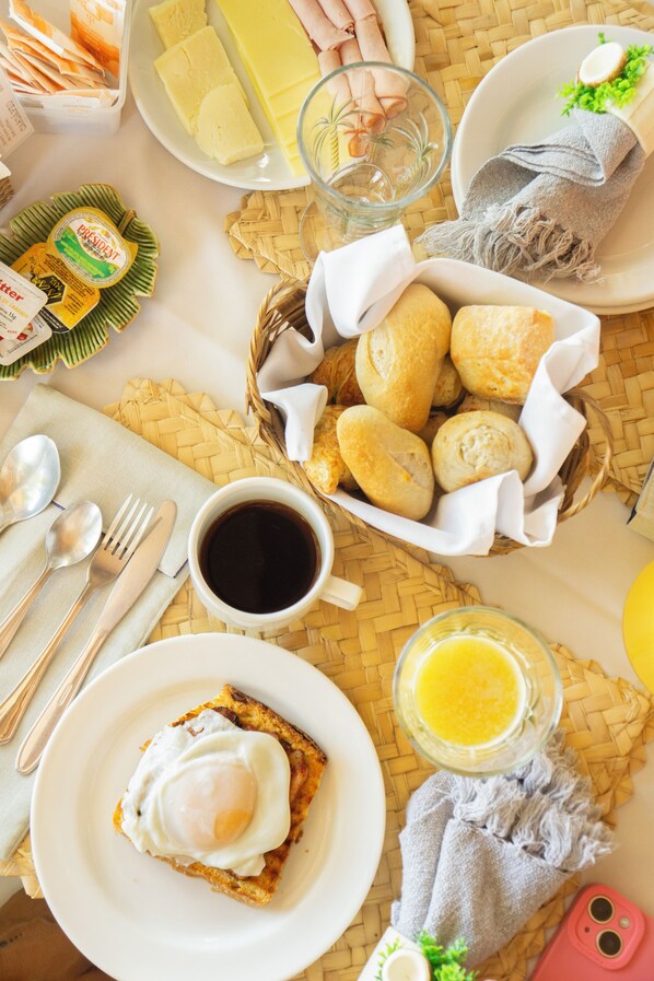 A breakfast setting with bread, eggs, coffee, and juice.