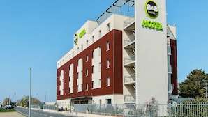 Un hotel B&B con diseño moderno, que cuenta con un cartel llamativo y un balcón en el piso superior.