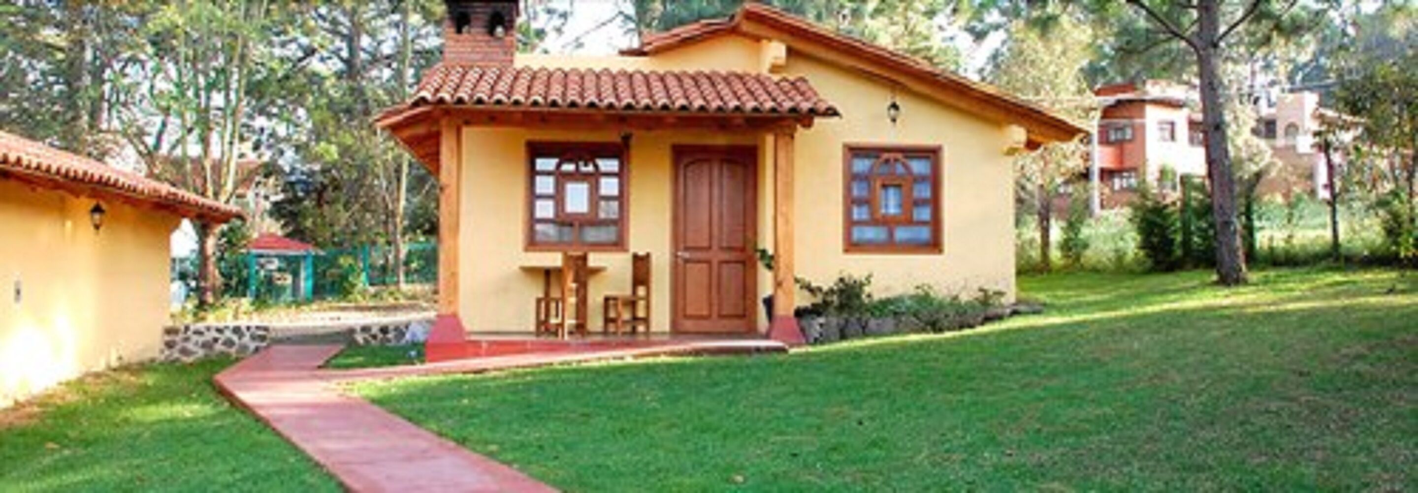 A small, single-story building with a tiled roof, a wooden door, and a window.