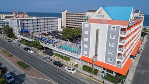 A hotel with a blue roof, a swimming pool, and a parking lot. - The Spinnaker Hotel (Ocean City)