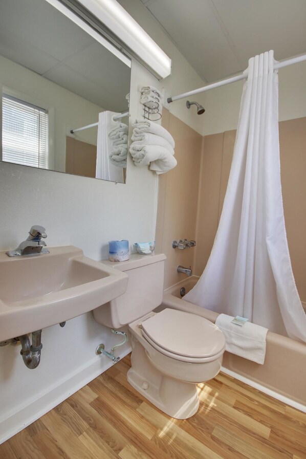 A bathroom with a sink, toilet, and shower area. - Thunderbird Beach Motel (Ocean City)