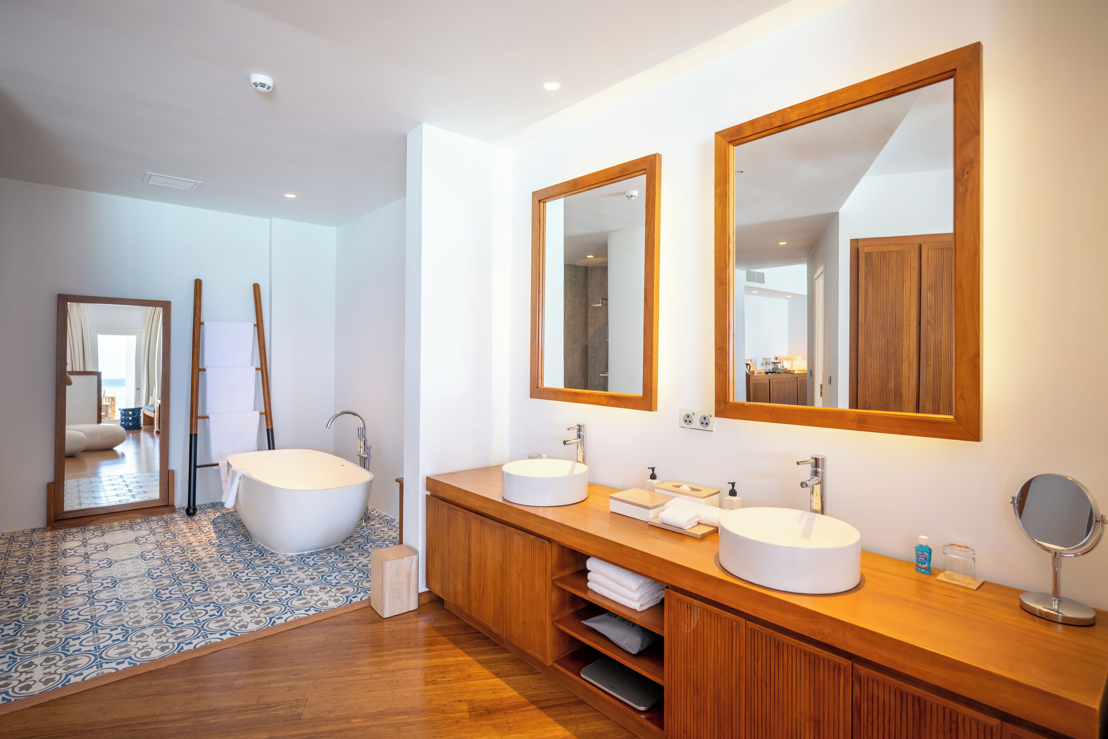 Un bagno moderno con due lavabi, ampi specchi e mobili in legno.