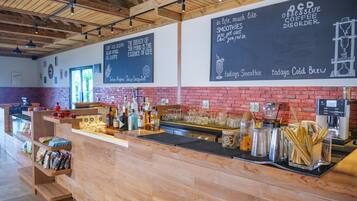 A coffee shop interior with a wooden counter, shelves with snacks, and chalkboard walls with motivational quotes.