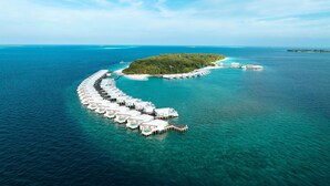 An aerial view of a resort island with overwater bungalows connected by a dock. - Amilla Maldives (Finolhas Island)