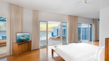 Ein modernes Hotelzimmer mit einem großen Bett, einem Fernseher auf einem Holzboden und einem Balkon mit Meerblick.