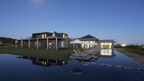 A modern house with a swimming pool, lounge chairs, and umbrellas. - Bahia Vik Jose Ignacio (José Ignacio)