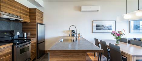 Una cocina moderna con armarios de madera, electrodomésticos de acero inoxidable y una isla central con asientos.