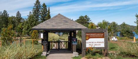 A gated entrance to a private club with a sign indicating it is a smoke-free environment.