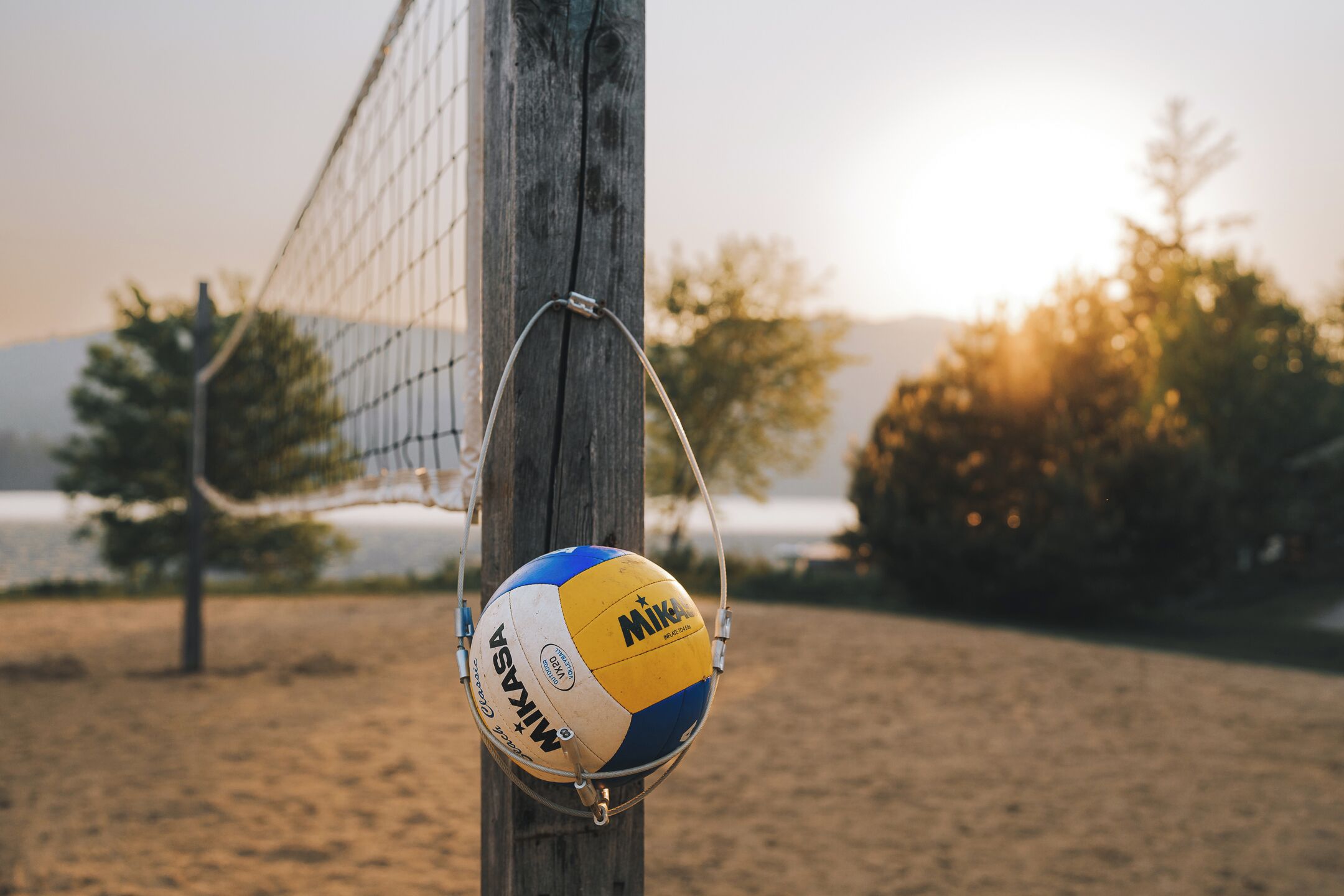 Een volleybal op een net met een houten paal.