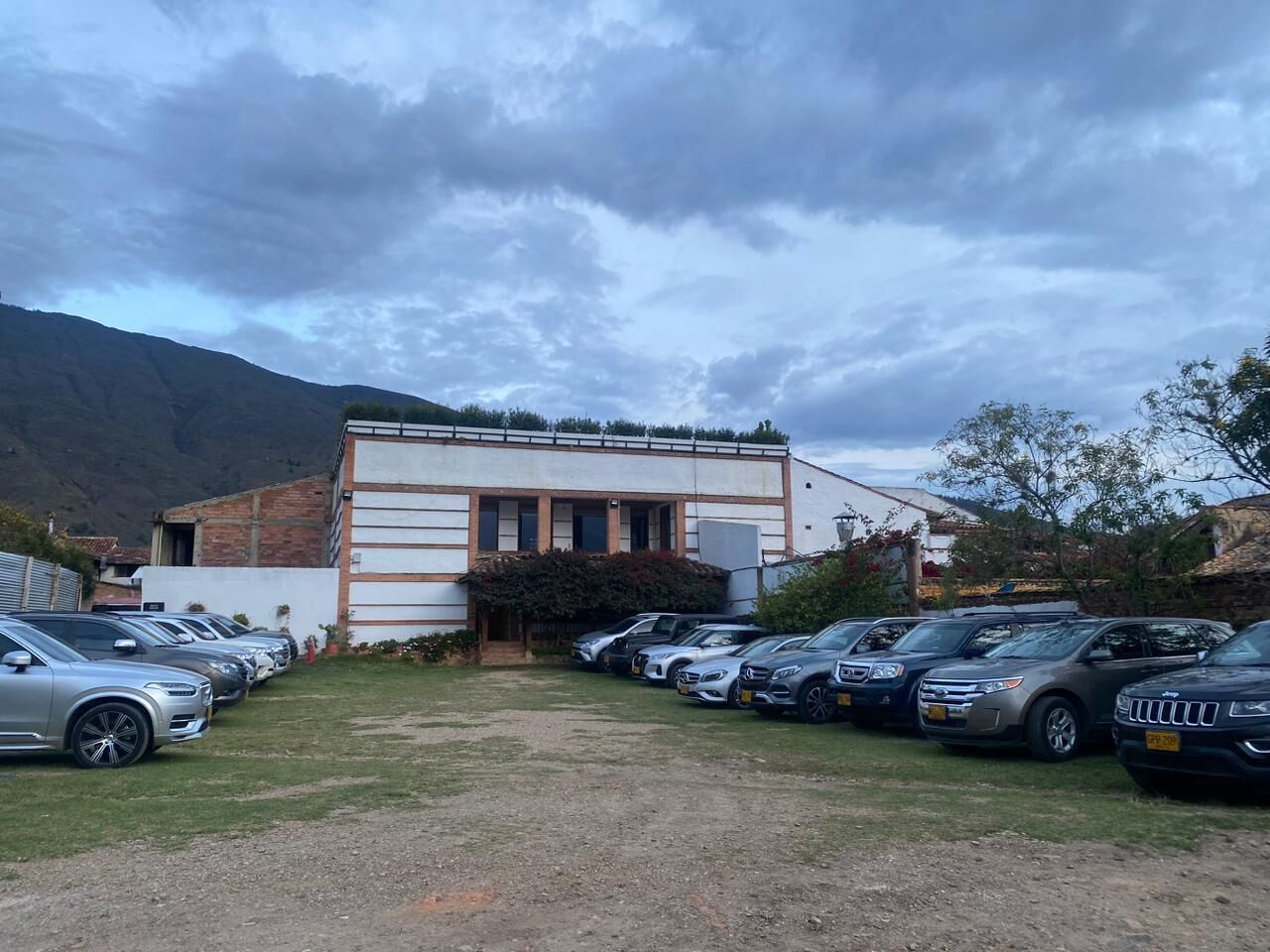A building with a parking lot containing several cars.