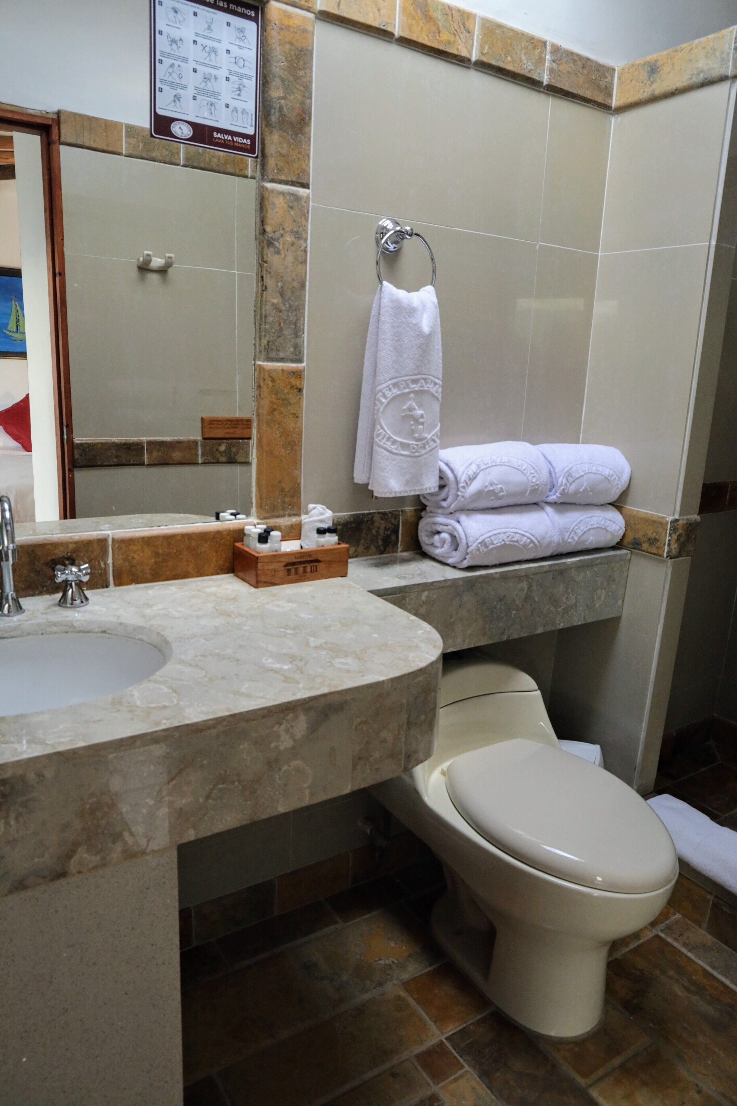 A bathroom with a sink, toilet, and a towel rack with folded towels.