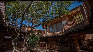 A traditional wooden building with multiple balconies and a large tree in the center. - Hotel Plaza Mayor (Villa de Leyva)