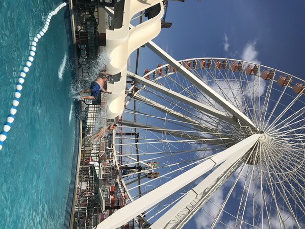 Une grande roue et un toboggan aquatique dans un parc d’attractions.