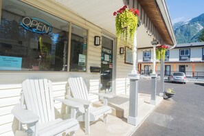 A building with an 'OPEN' sign, a '510' address, and a 'Very Good 8.0' rating. There are white Adirondack chairs outside.