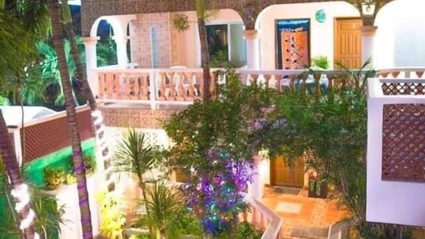 A courtyard with a central open area, surrounded by multiple levels of balconies and a white fence. - Francis Arlene - Adults Only (Isla Mujeres)