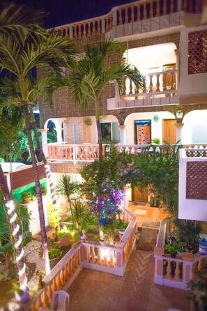 A courtyard with a central open area, surrounded by multiple levels of balconies and a white fence. - Francis Arlene - Adults Only (Isla Mujeres)