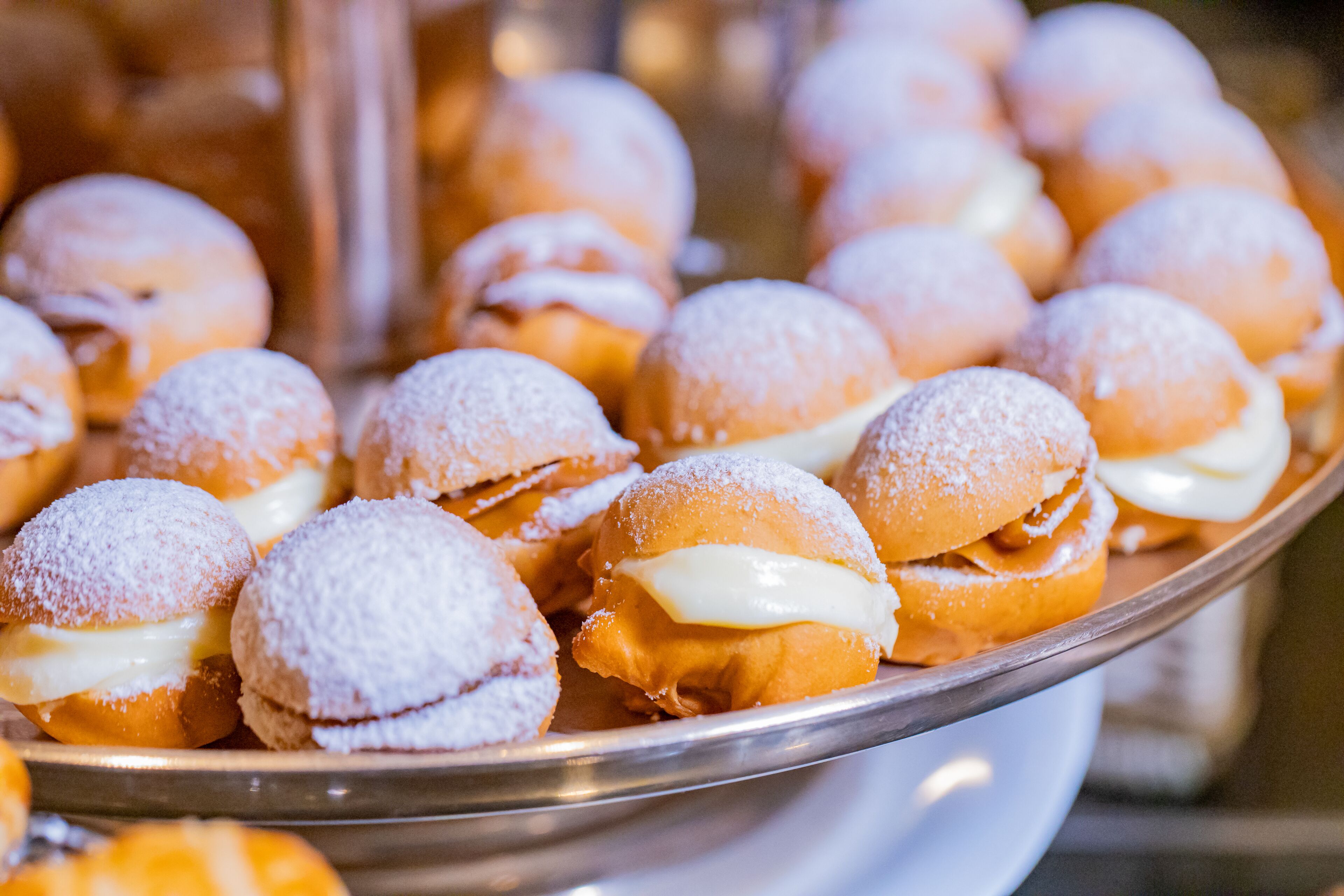 Een schaal met gebakjes bedekt met poedersuiker, waarschijnlijk een dessert.