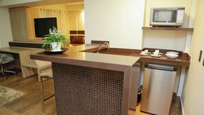 Una cocina compacta con microondas, lavavajillas y un pequeño comedor.