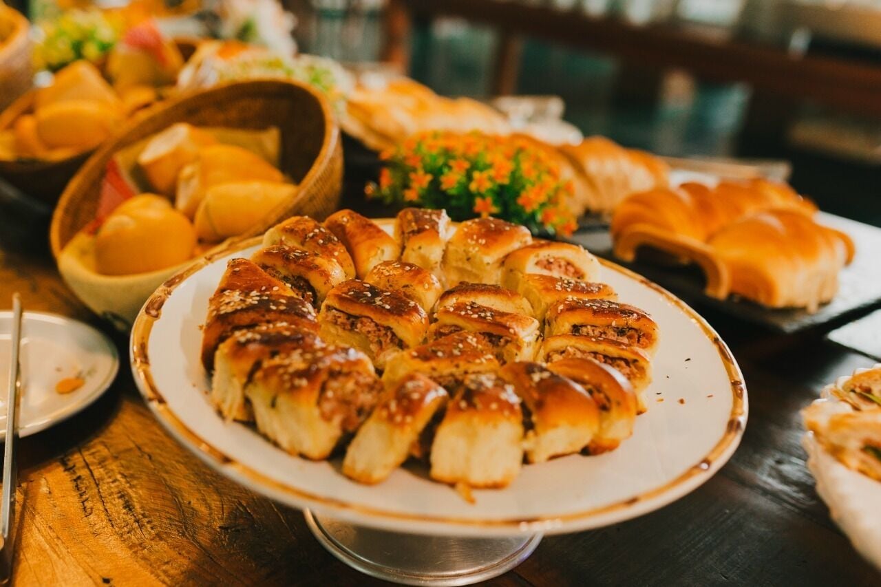 A variety of baked goods on a table, including bread rolls and pastries.