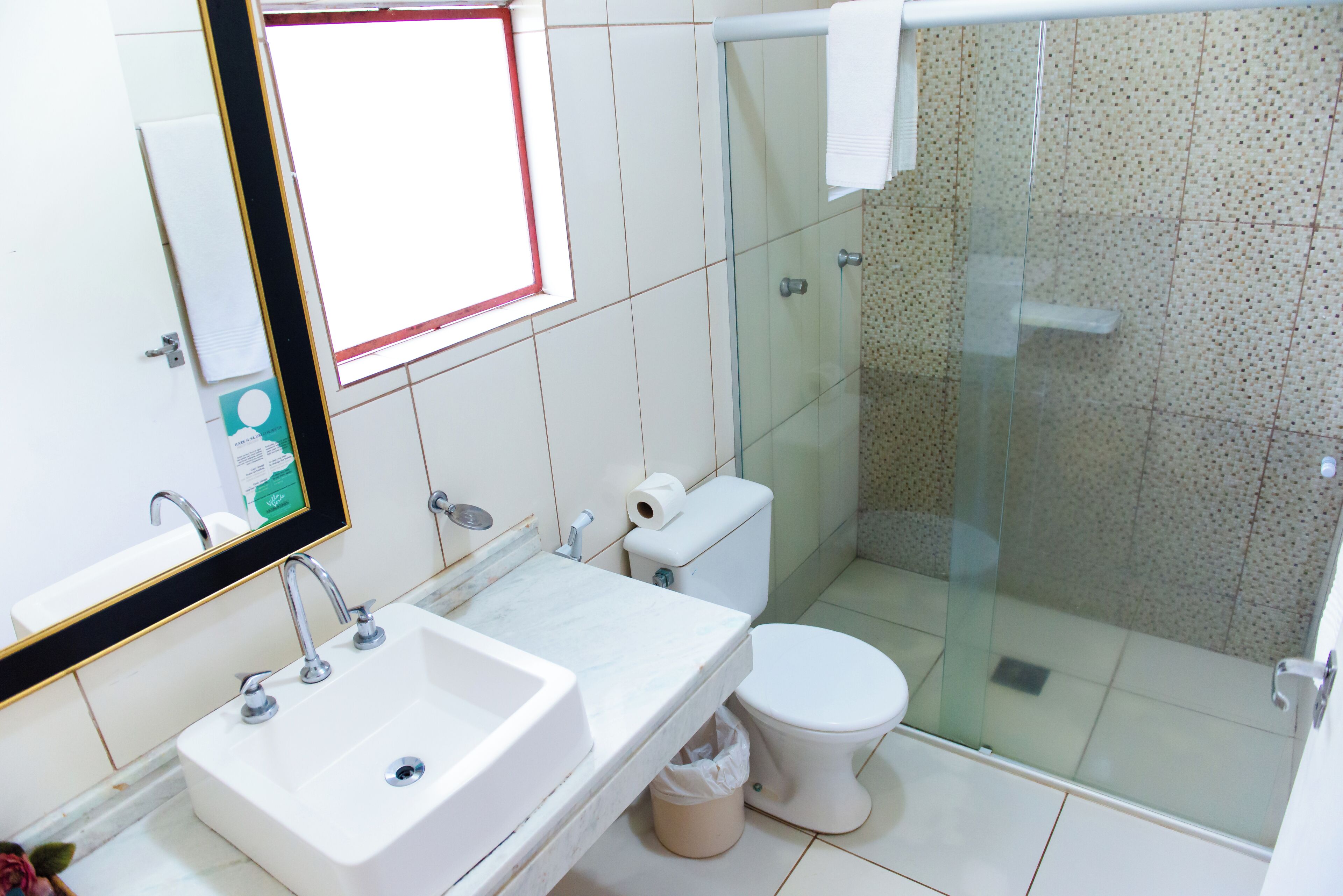 A bathroom with a sink, toilet, and glass-enclosed shower.