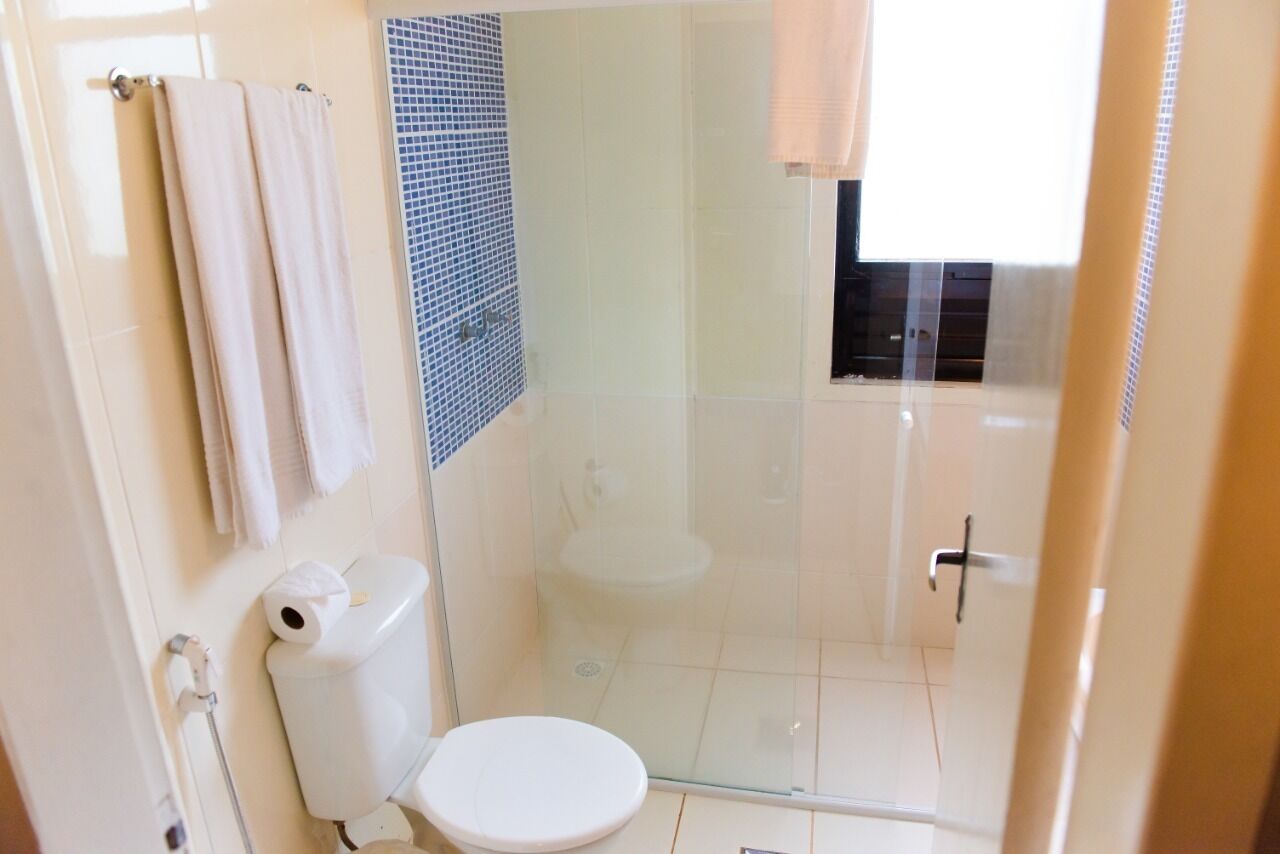 A bathroom with a toilet, a shower, and a glass door.