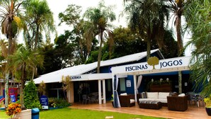 A building with a sign reading "PISCINAS JOGOS" and "CADEMIA". - Villa Verde Hotel (Avare)