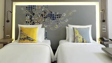 Une chambre d’hôtel avec deux lits, une tête de lit moderne et un élément décoratif mural.