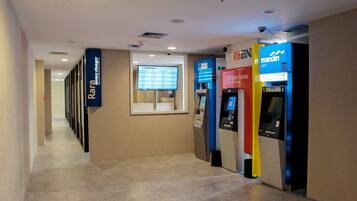 A hallway with currency exchange, a bank ATM, and a 'Rara Money Changer' sign.