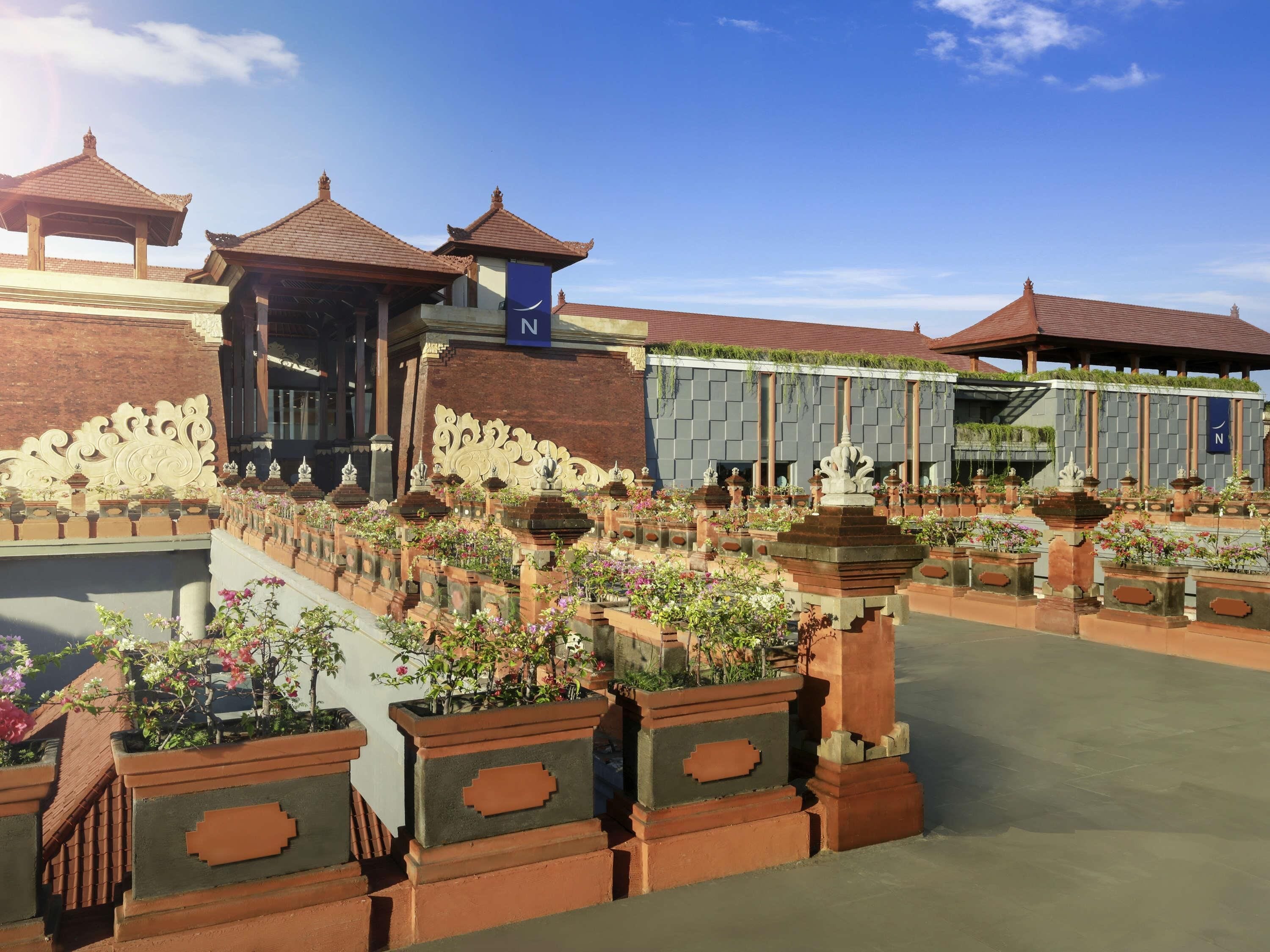 A traditional courtyard with tiled roofs, ornate pillars, and a water feature.