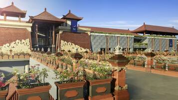 A traditional courtyard with tiled roofs, ornate pillars, and a water feature.