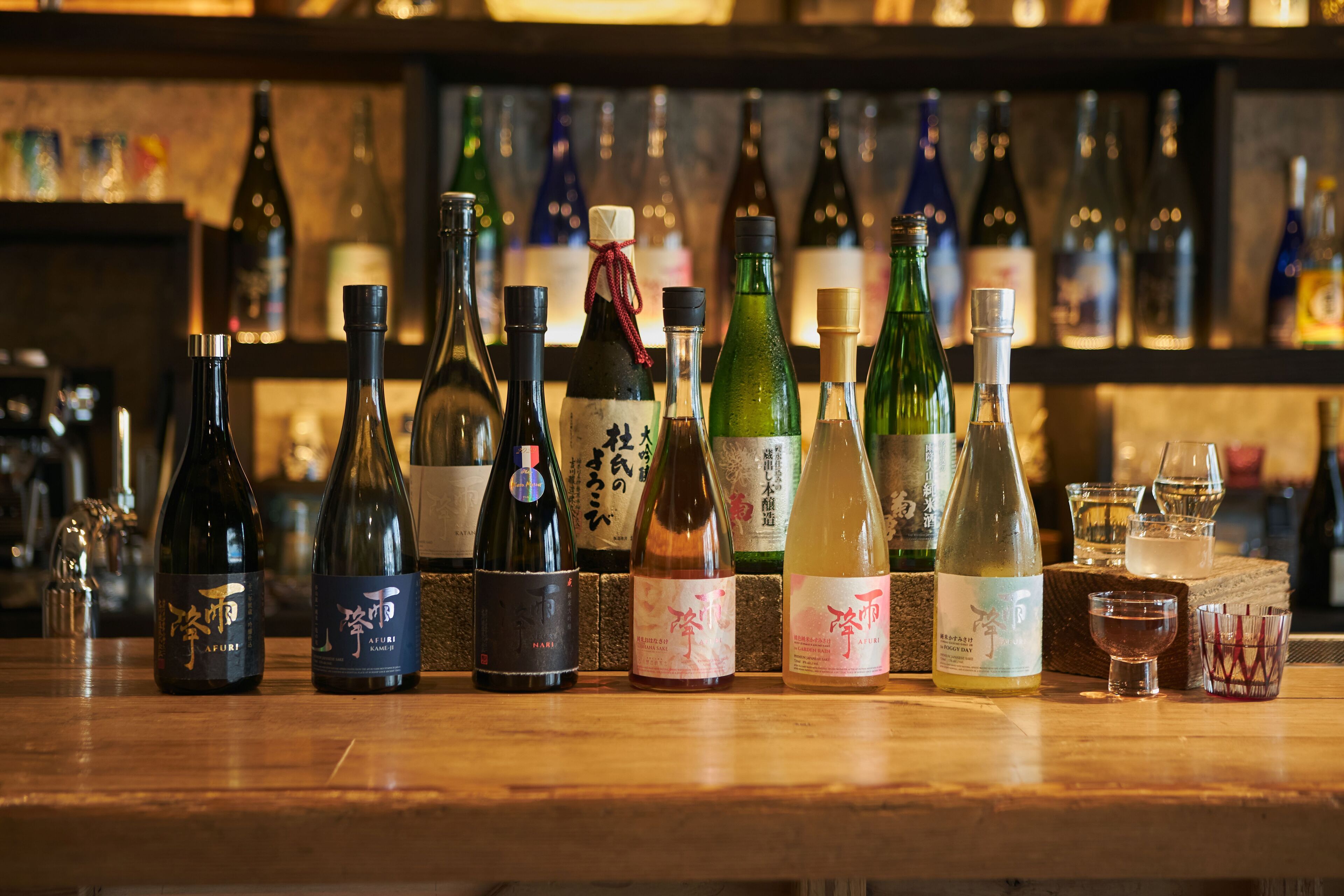 Varias botellas de vino sobre una barra de madera.