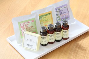 A tray with bath products including a soap bar, shampoo, conditioner, and body lotion.