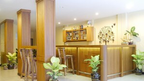 A reception area with wooden furniture, a bar, and potted plants. - Golden Moon Aonang (Krabi)