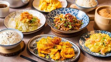 A variety of dishes including rice, fried items, and a teapot.