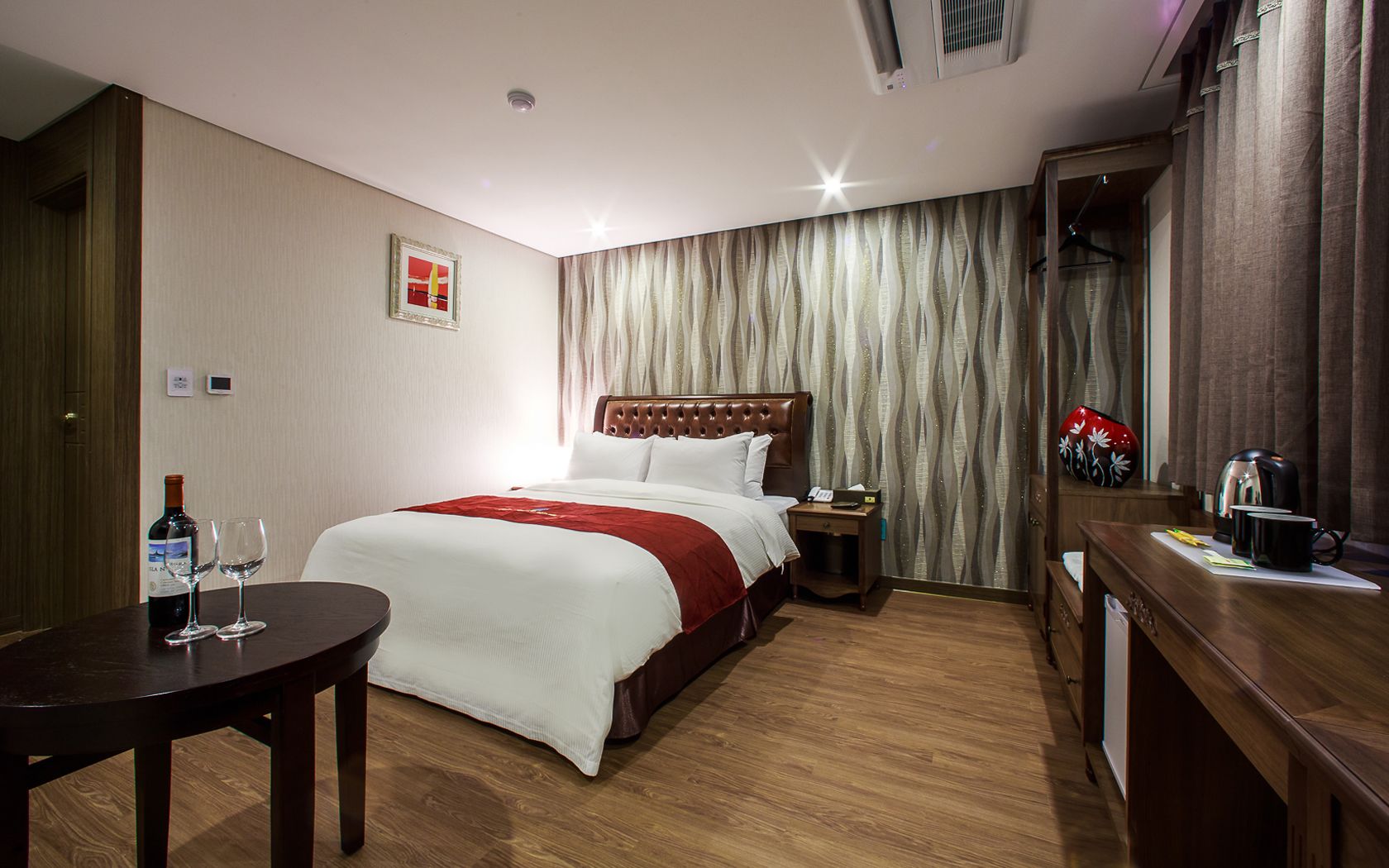 Habitació d'hotel amb un llit, una taula de nit i un escriptori amb una cadira.