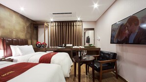A hotel room with two beds, a desk with a computer, a chair, a TV, and a coffee maker. - Harmony Hotel (Seoul)