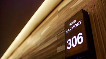 A hotel sign with the name "HARMONY" and room number "306".