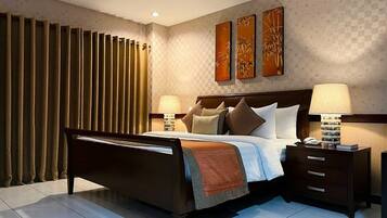 A modern hotel bedroom with a large bed, two bedside tables, and a nightstand.