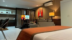 Una habitación de hotel con cama, televisión, escritorio y silla.