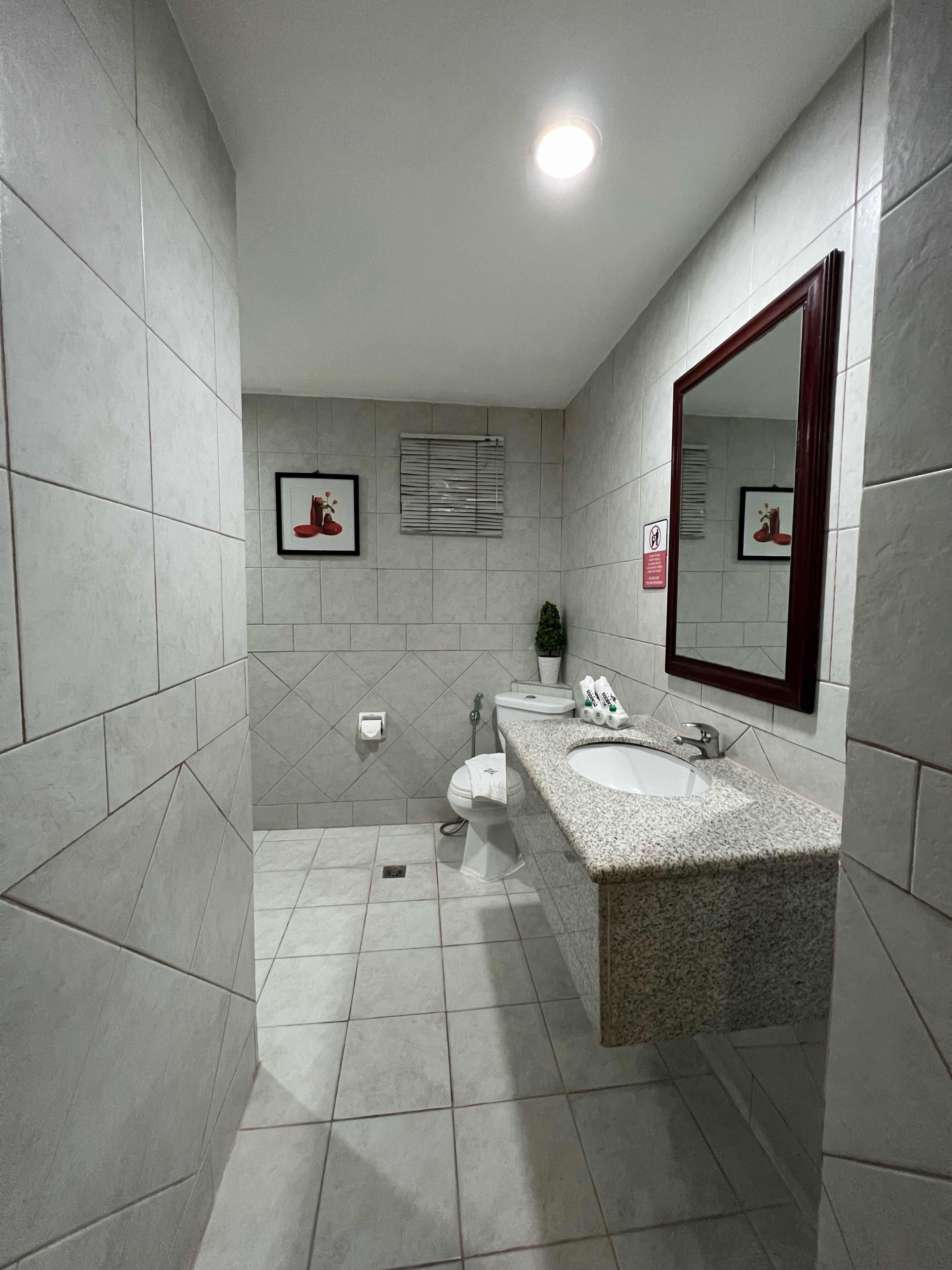 Un baño moderno con un espejo grande, dos lavabos, un inodoro y una ducha.