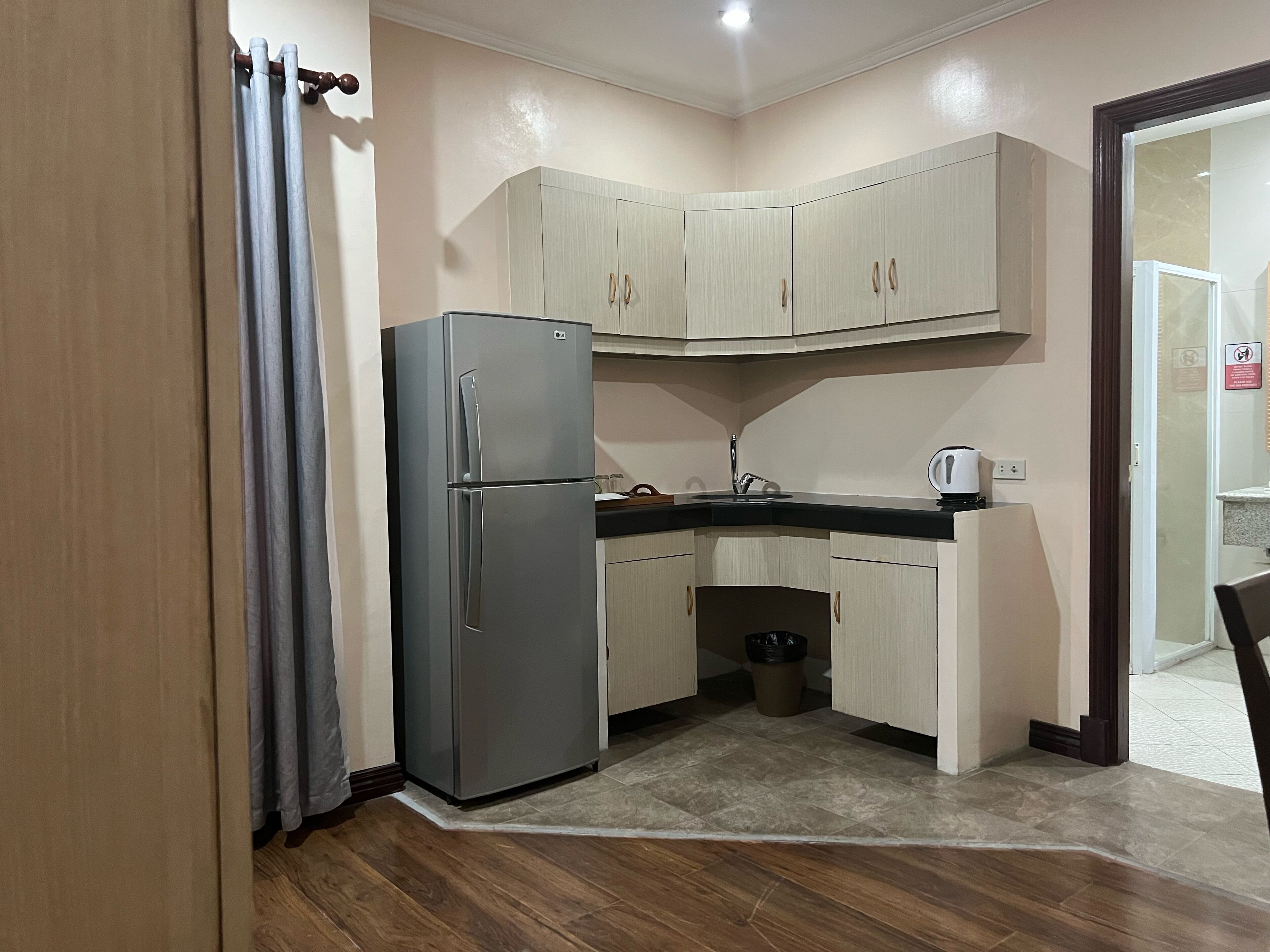 A compact kitchen with a refrigerator, cabinets, and a sink.