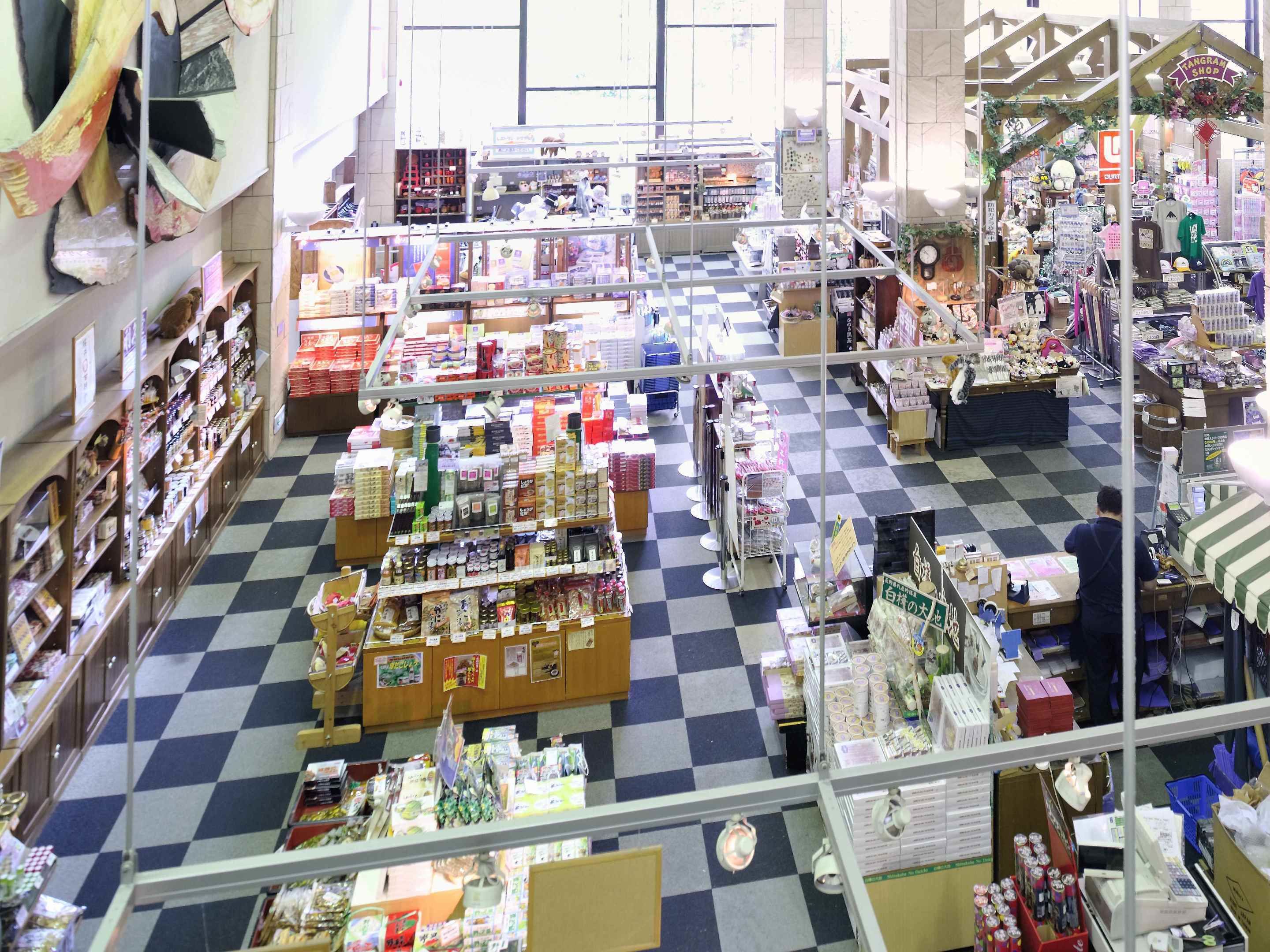 A spacious store with a checkered floor, various shelves stocked with goods, and a central aisle for easy navigation.